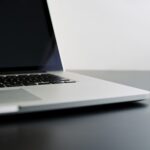 silver laptop computer on black table